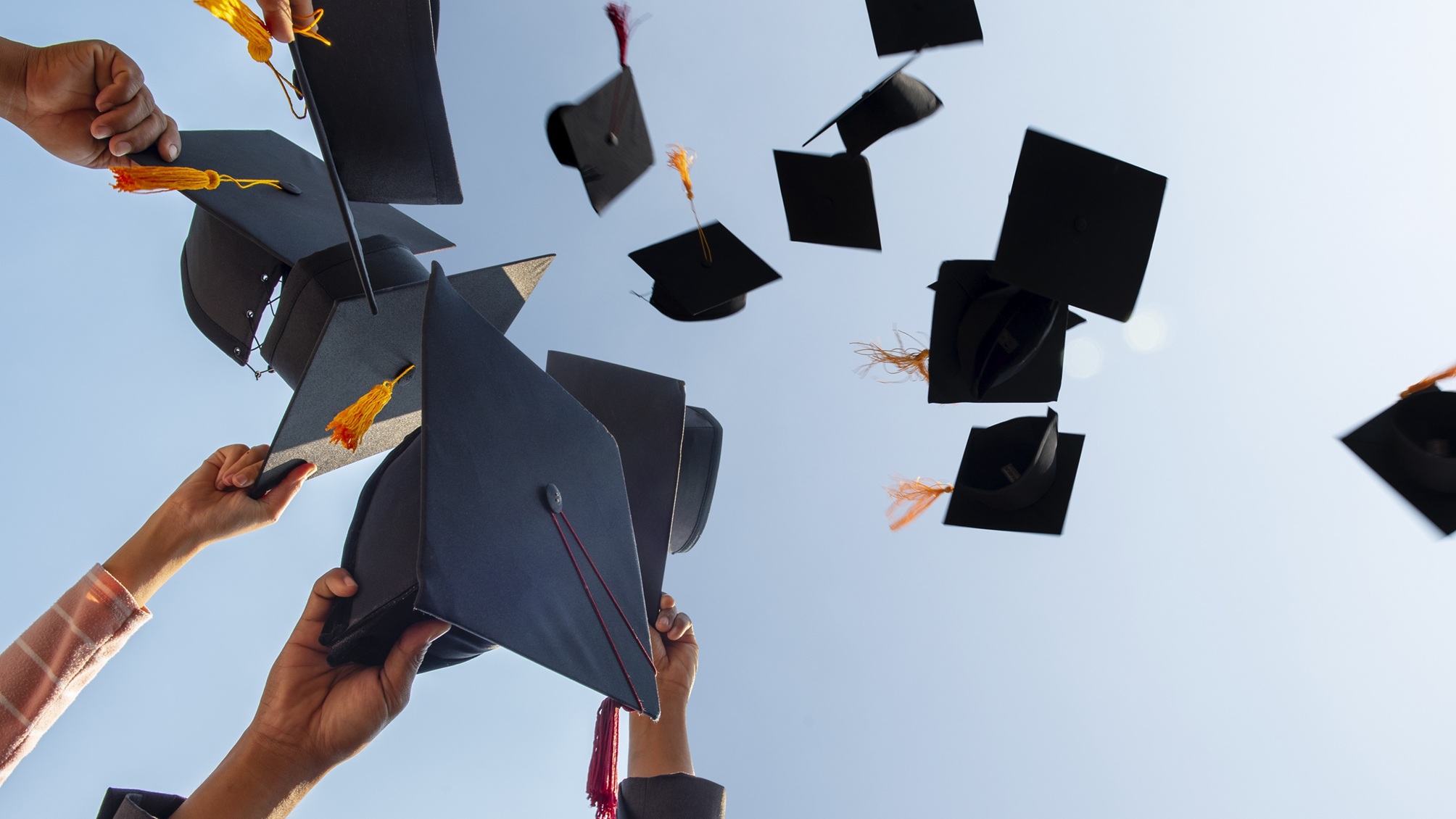 Les diplômés jettent leurs planches de mortier en l'air.