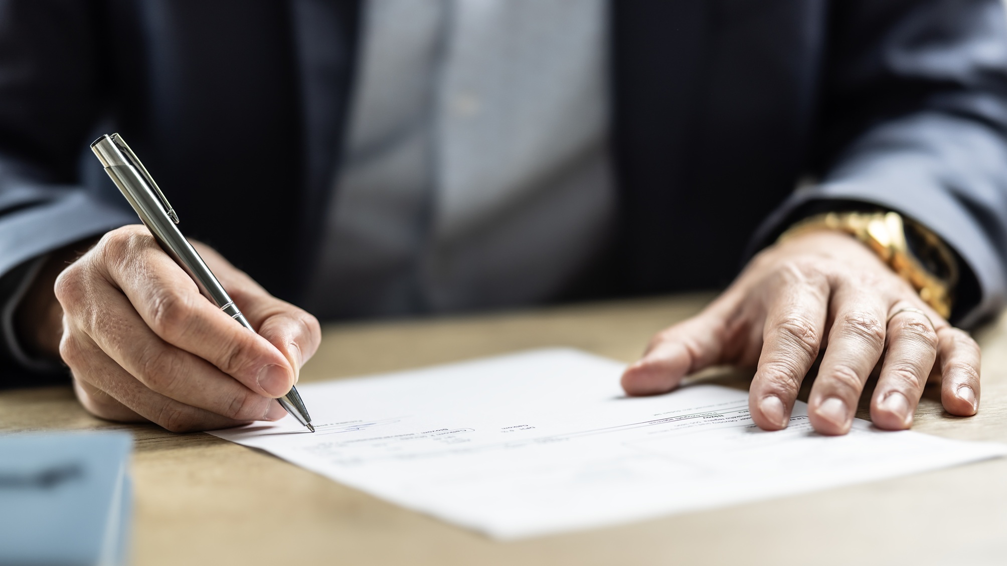 Seules les mains d’un homme d’affaires apparaissent lorsqu’il signe un document.