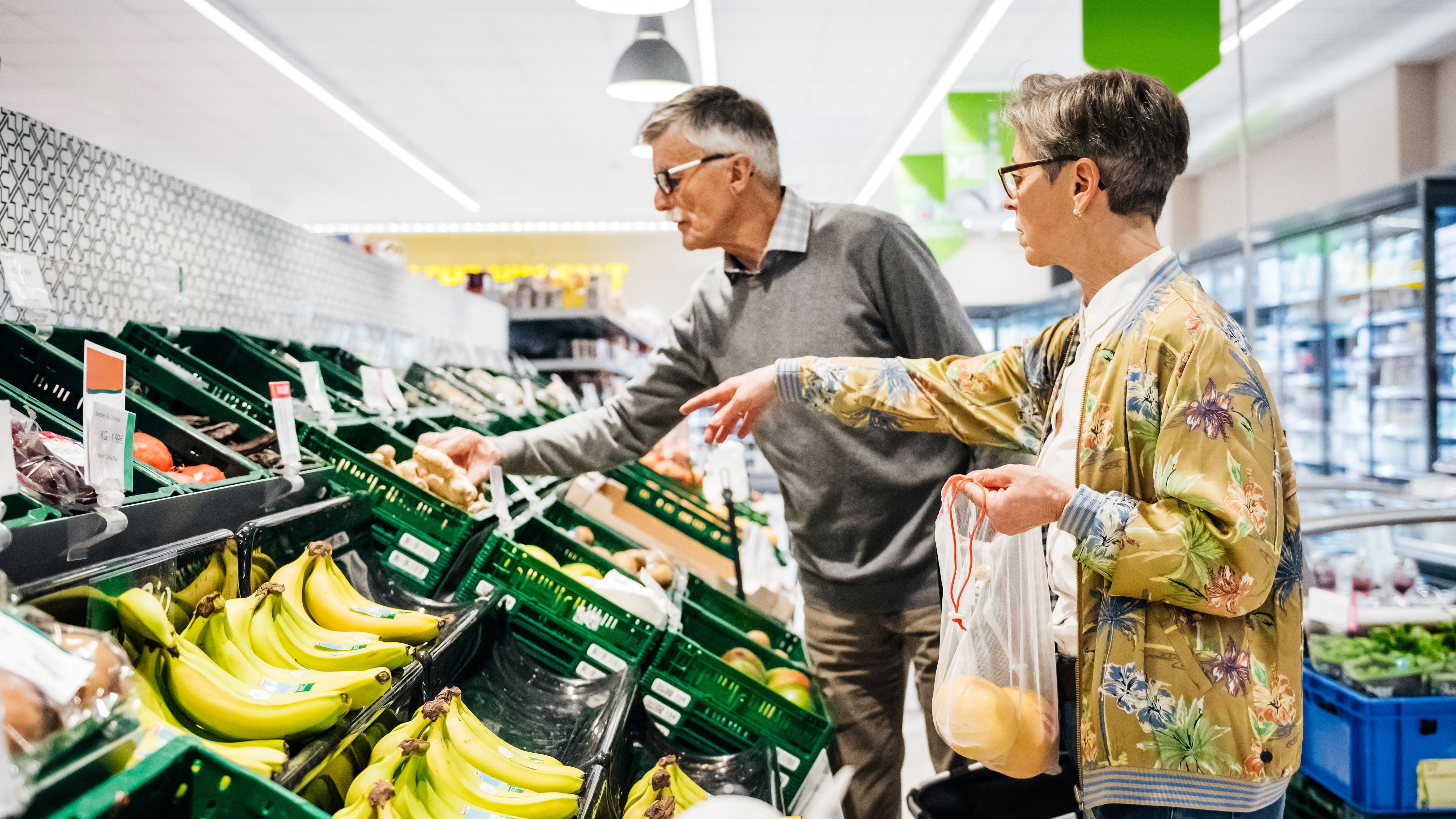 Couple de personnes âgées achetant des fruits et légumes ensemble