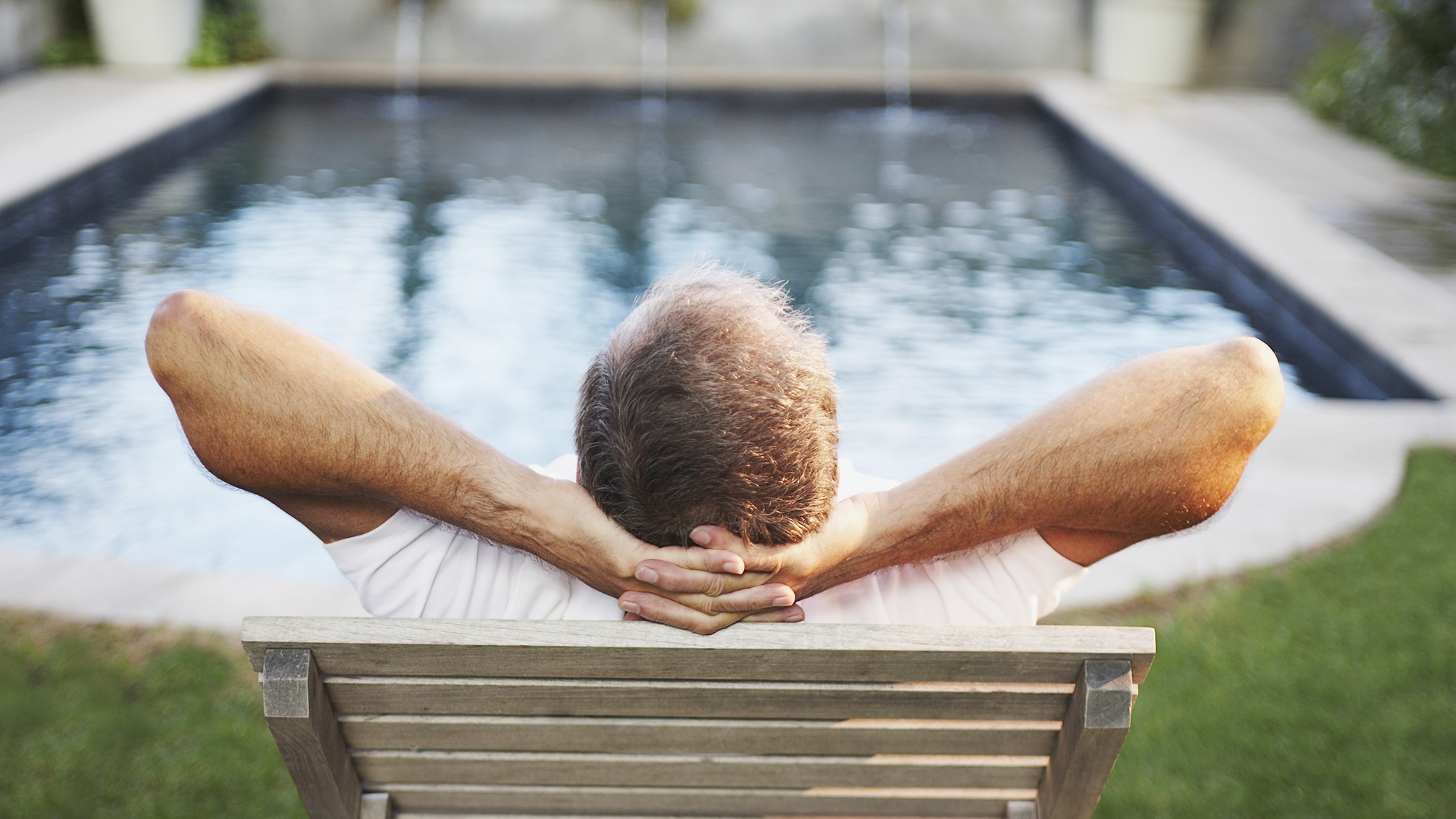 Un homme plus âgé se détend face à une piscine.