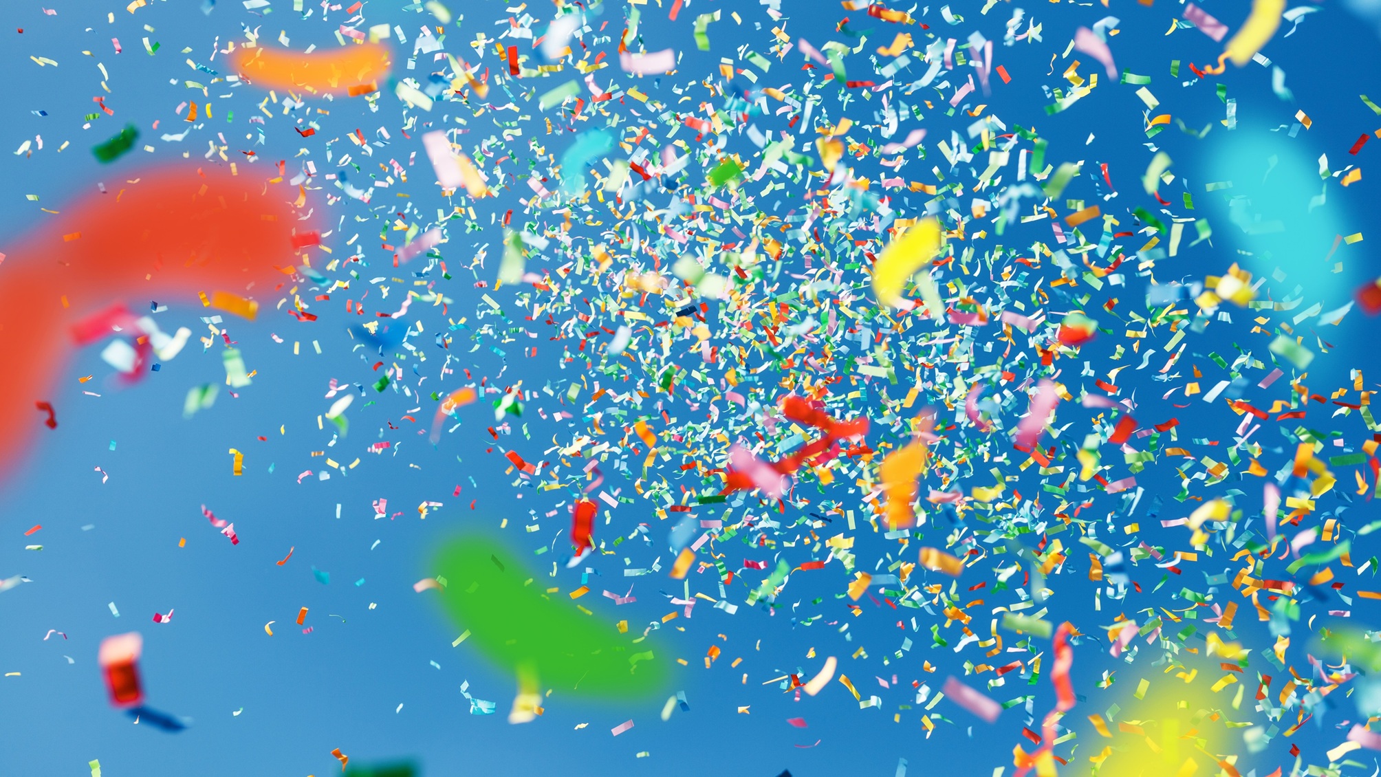 Confettis volant dans les airs sur fond bleu.