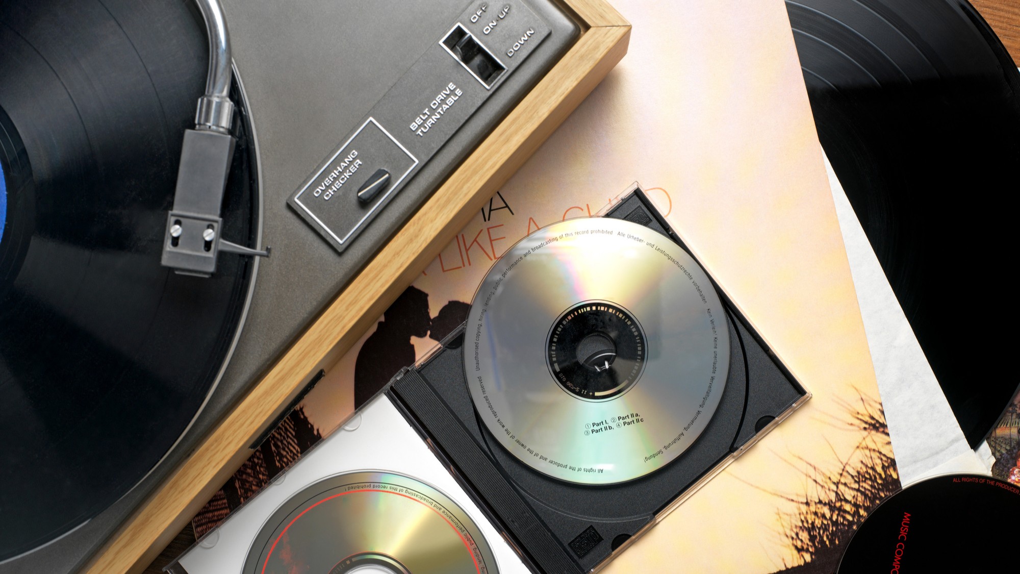 Une chaîne stéréo vintage avec des CD et une pochette de disque.