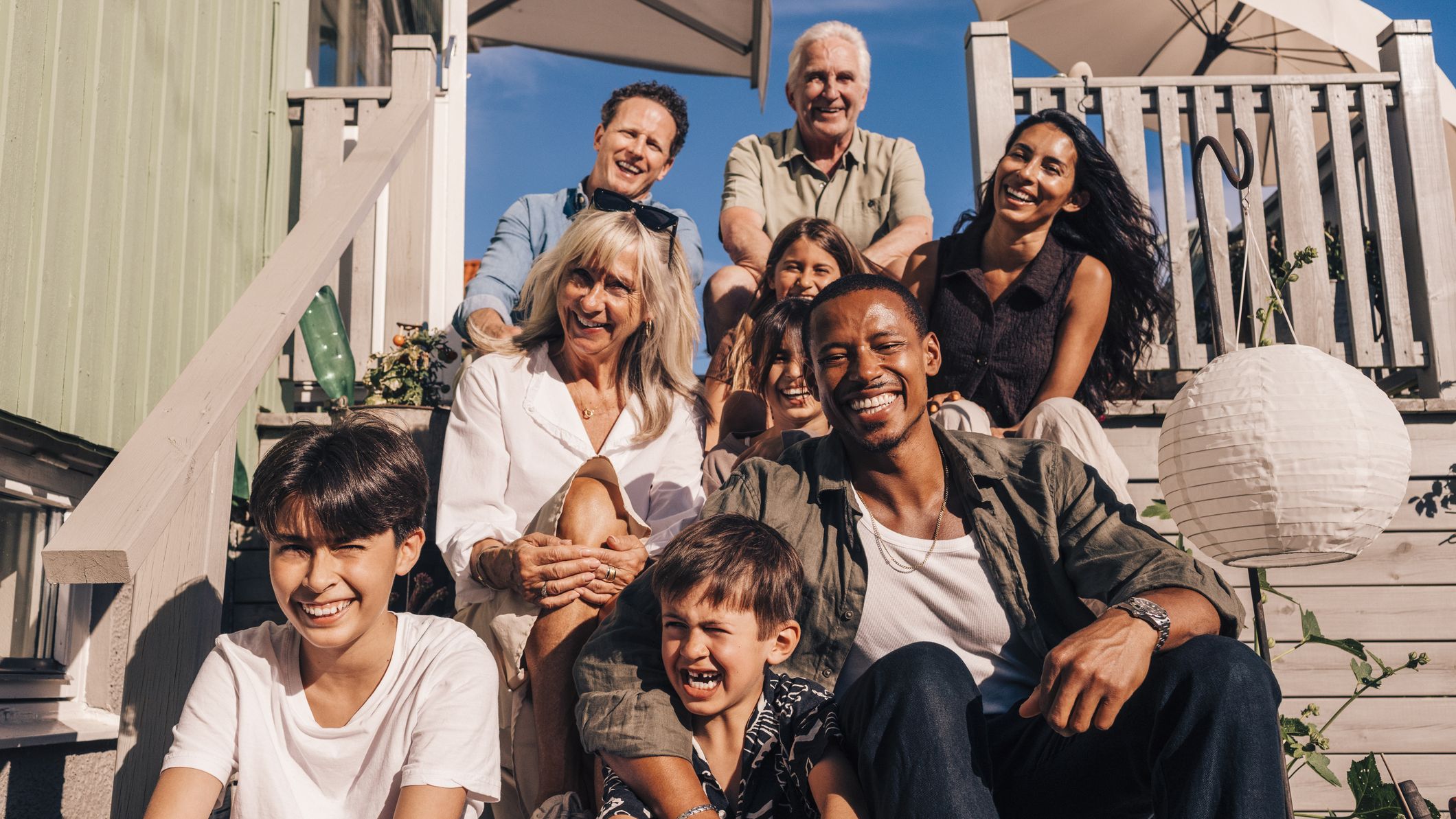 Famille assise sur les marches d’une maison de plage.