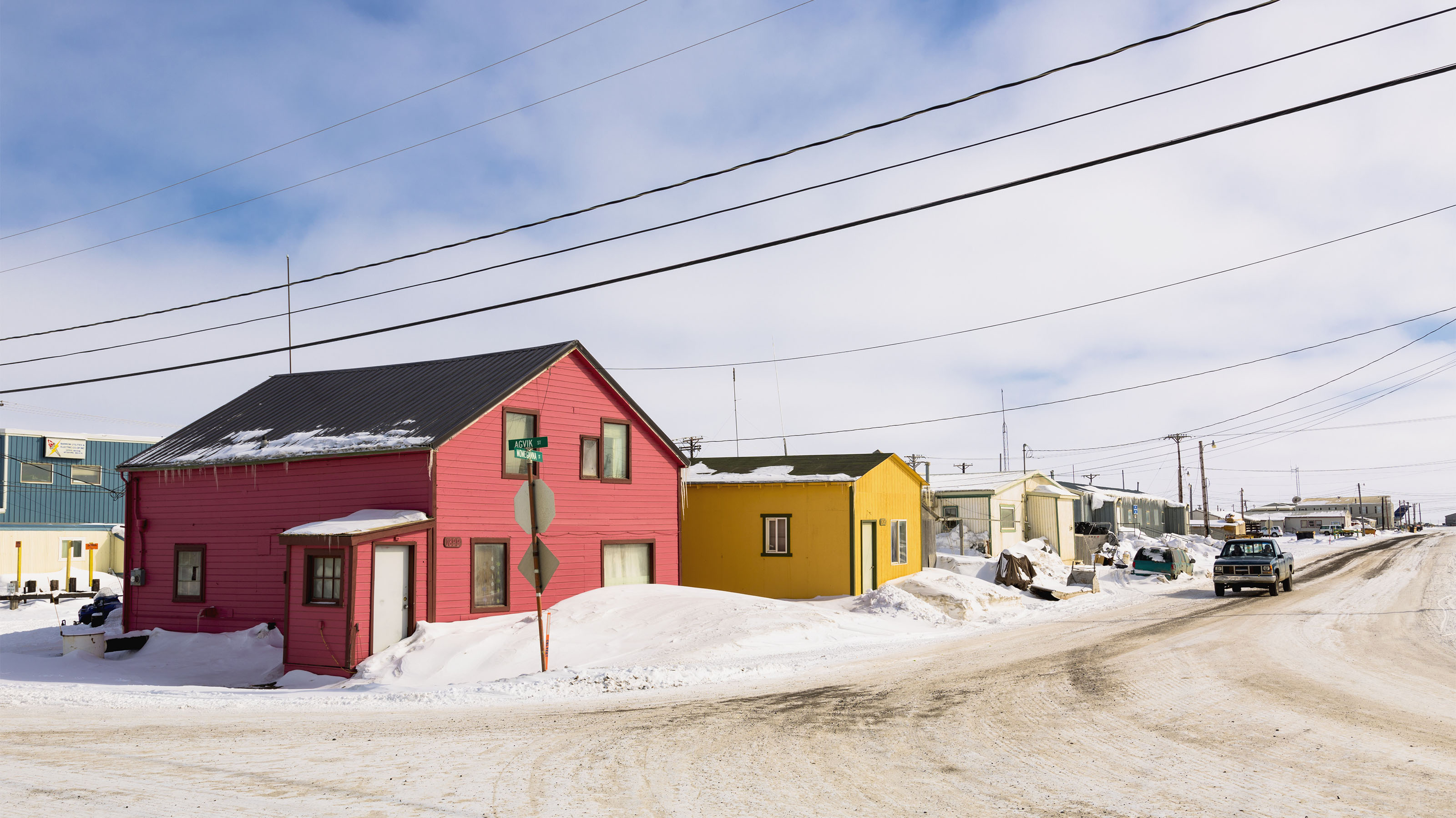 Maison rouge et jaune dans une rue enneigée en Alaska