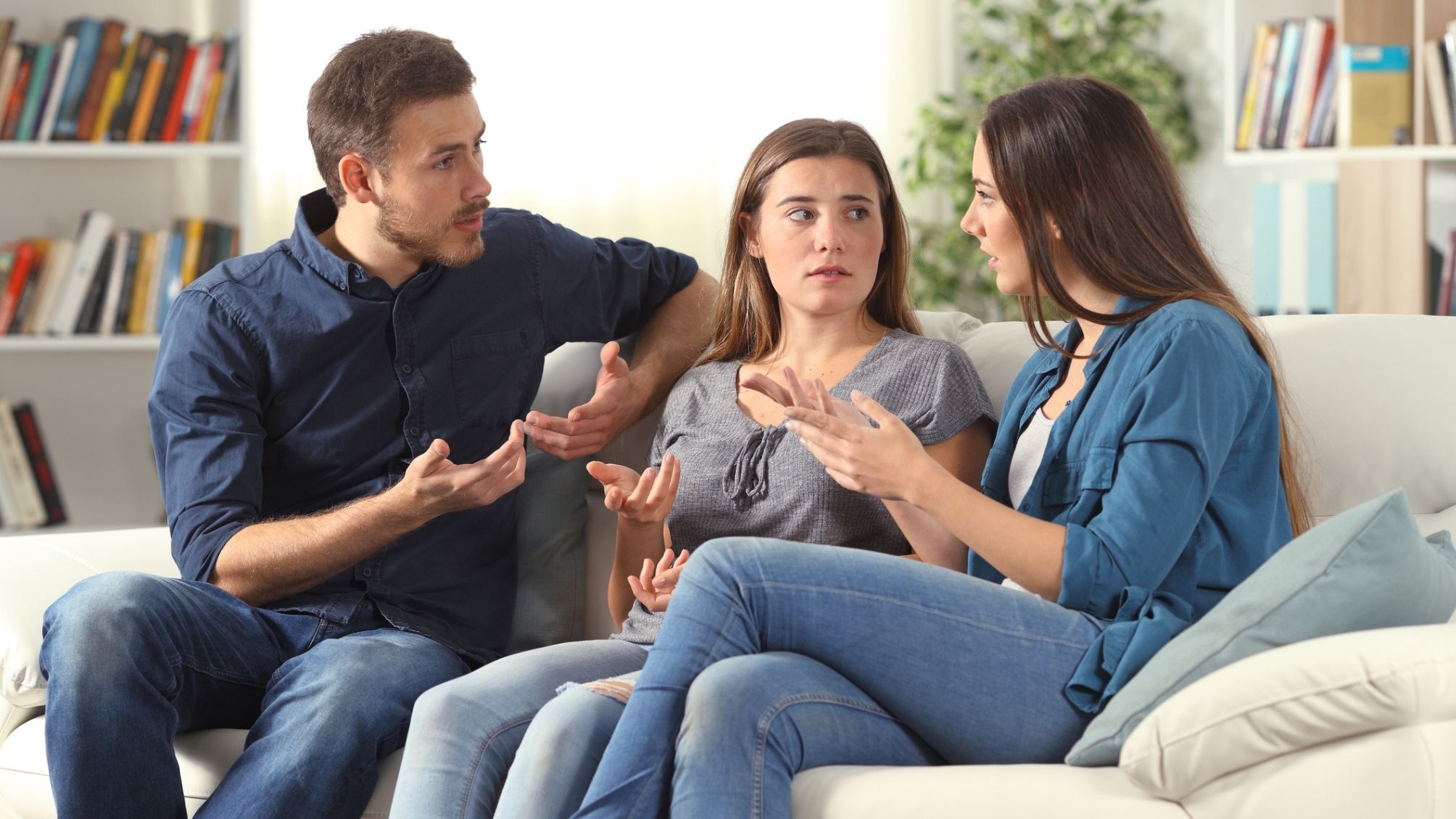 3 frères et sœurs assis sur un canapé discutant d'importantes affaires familiales