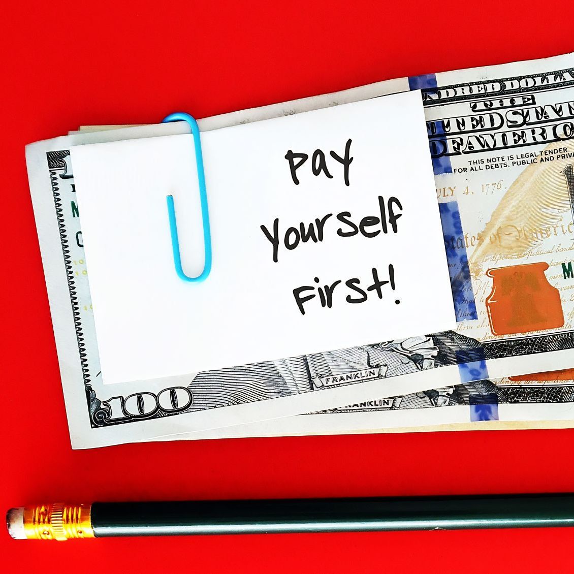 Une pile d'argent liquide avec un papier attaché dessus qui dit "Payez-vous d'abord !"