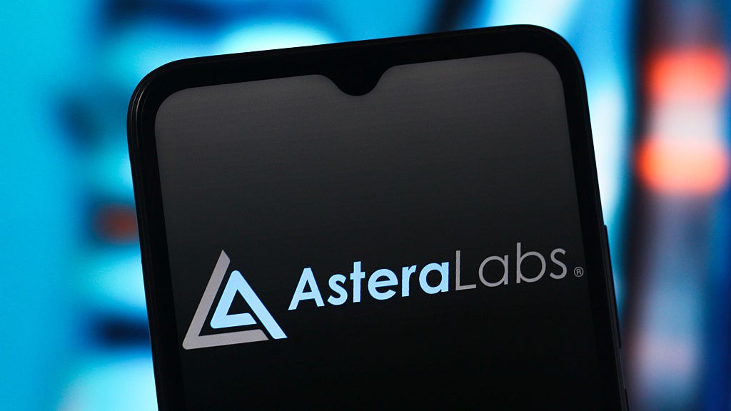 Logo Astera Labs sur un smartphone avec des lumières bleues et rouges floues en arrière-plan