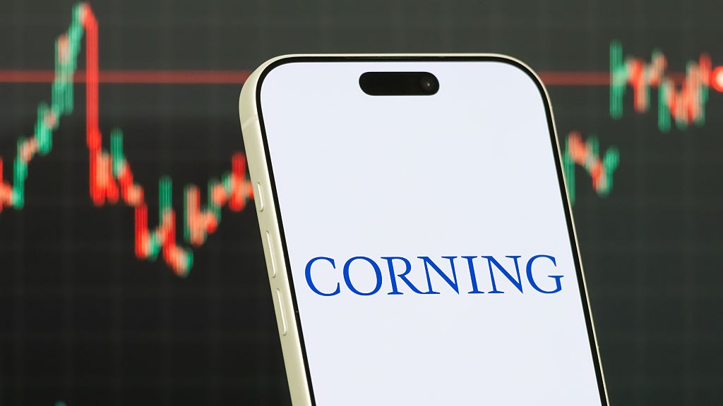 Logo Corning sur un smartphone avec un graphique boursier flou en arrière-plan