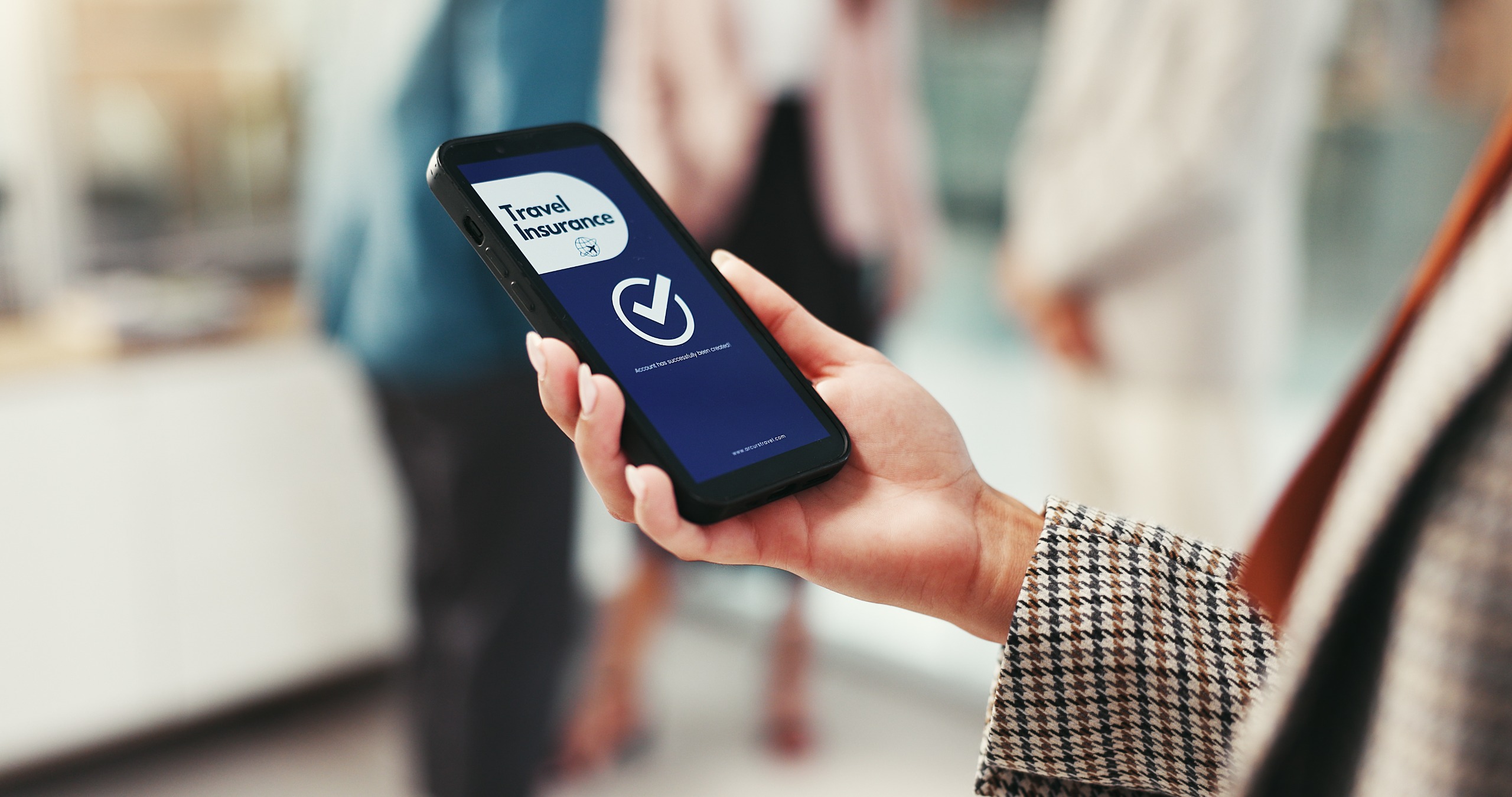 Une femme voit une page de confirmation d’achat sur son téléphone après avoir souscrit une assurance voyage.