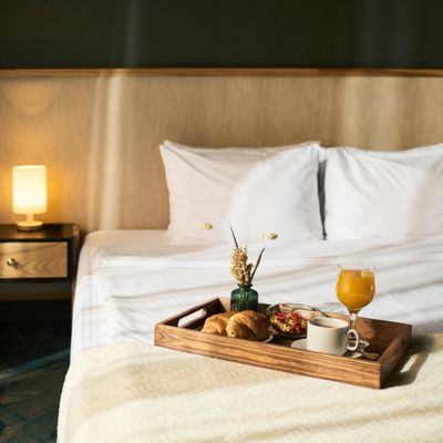Un plateau de room service assis sur un lit dans une jolie chambre d'hôtel.