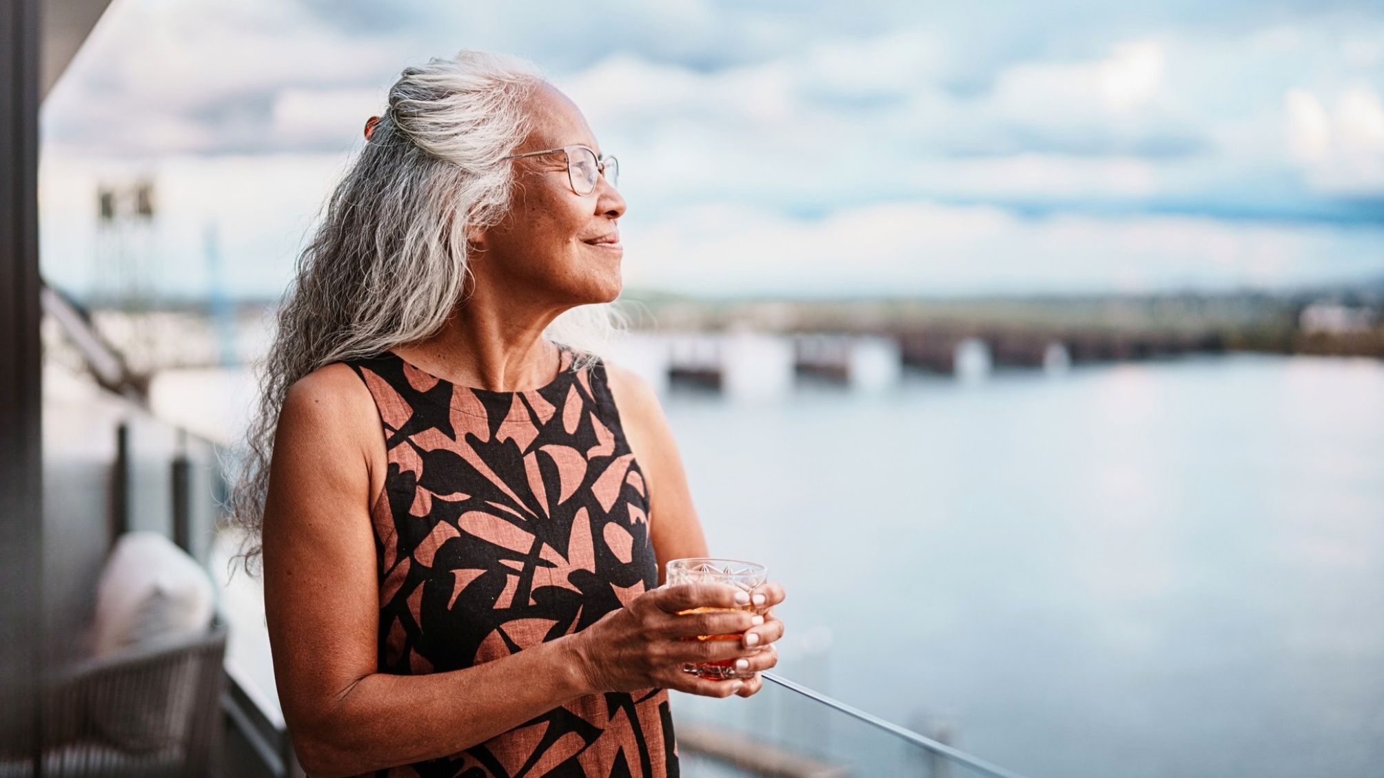 Une femme profitant de la vue depuis le balcon de sa chambre d’hôtel.