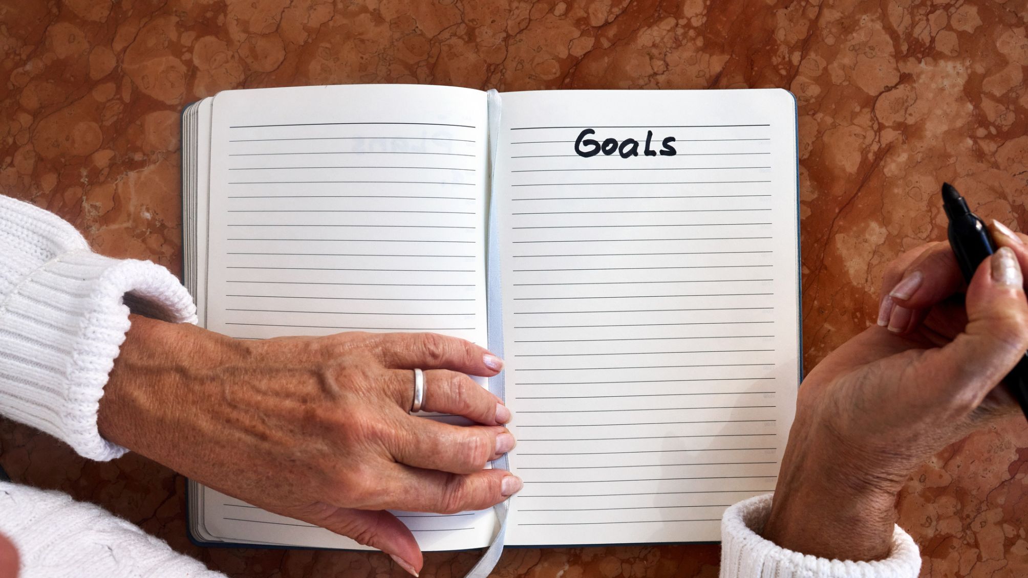 Une personne qui écrit des objectifs dans un cahier.