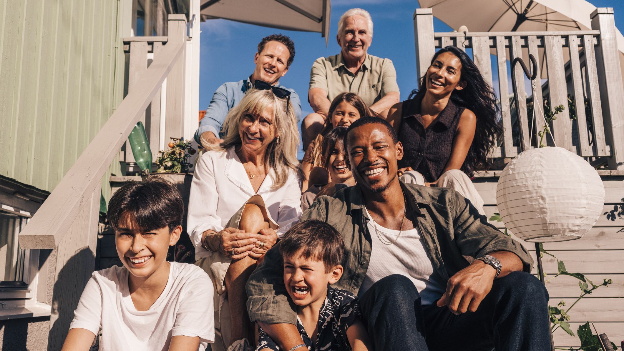 Famille assise sur les marches d’une maison de plage.