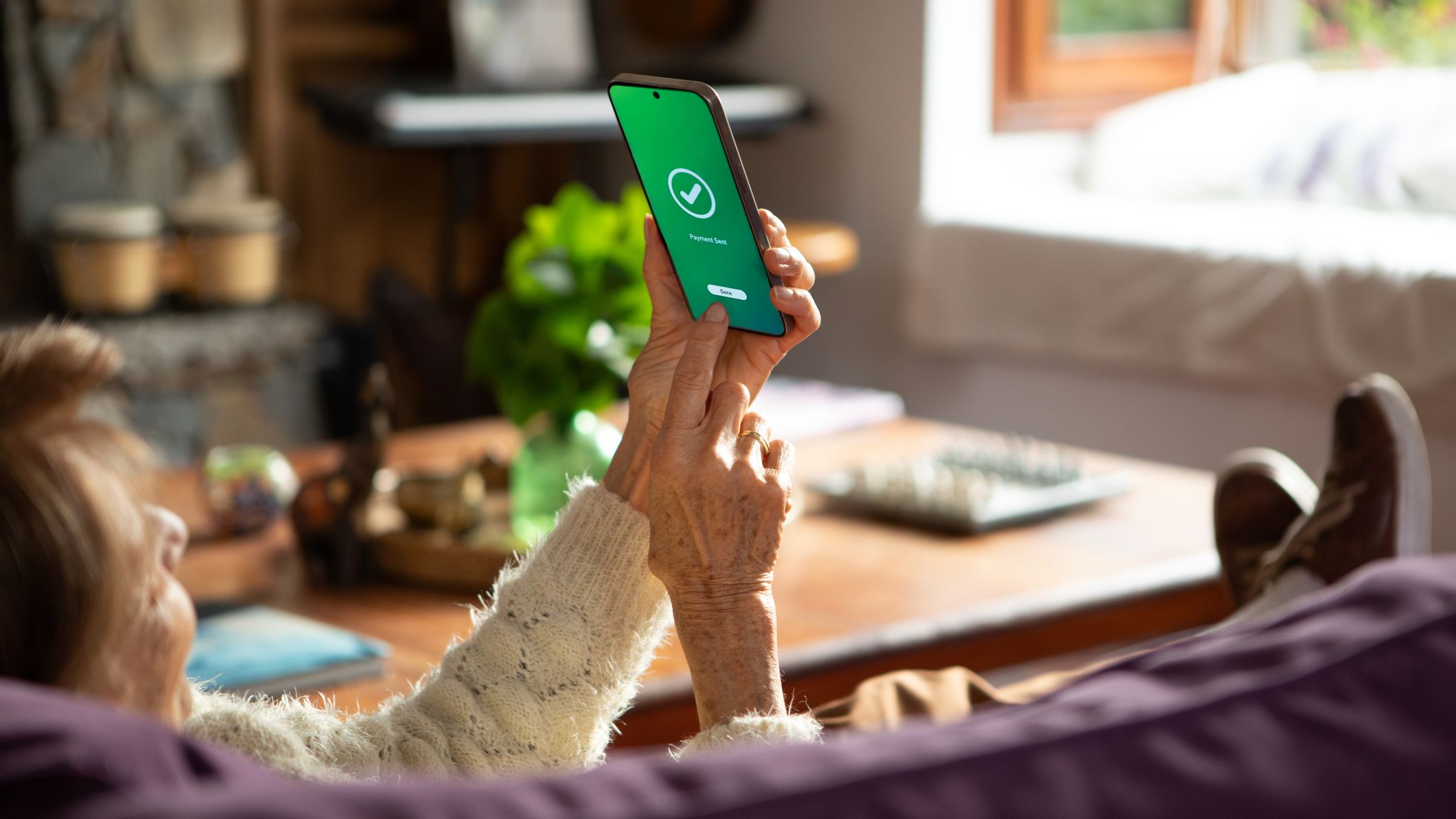 un homme voit une notification sur son téléphone concernant un transfert d'argent terminé