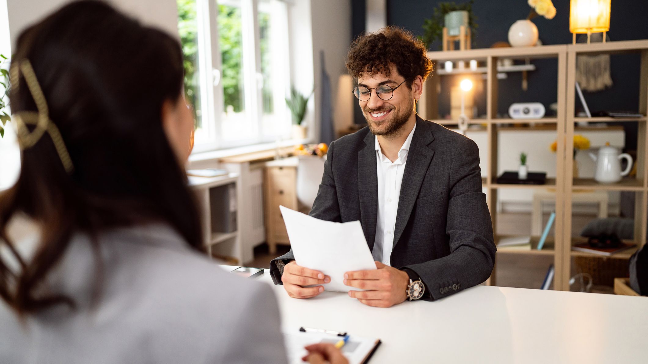 Jeune candidat masculin ayant un entretien avec une recruteuse/RH au bureau