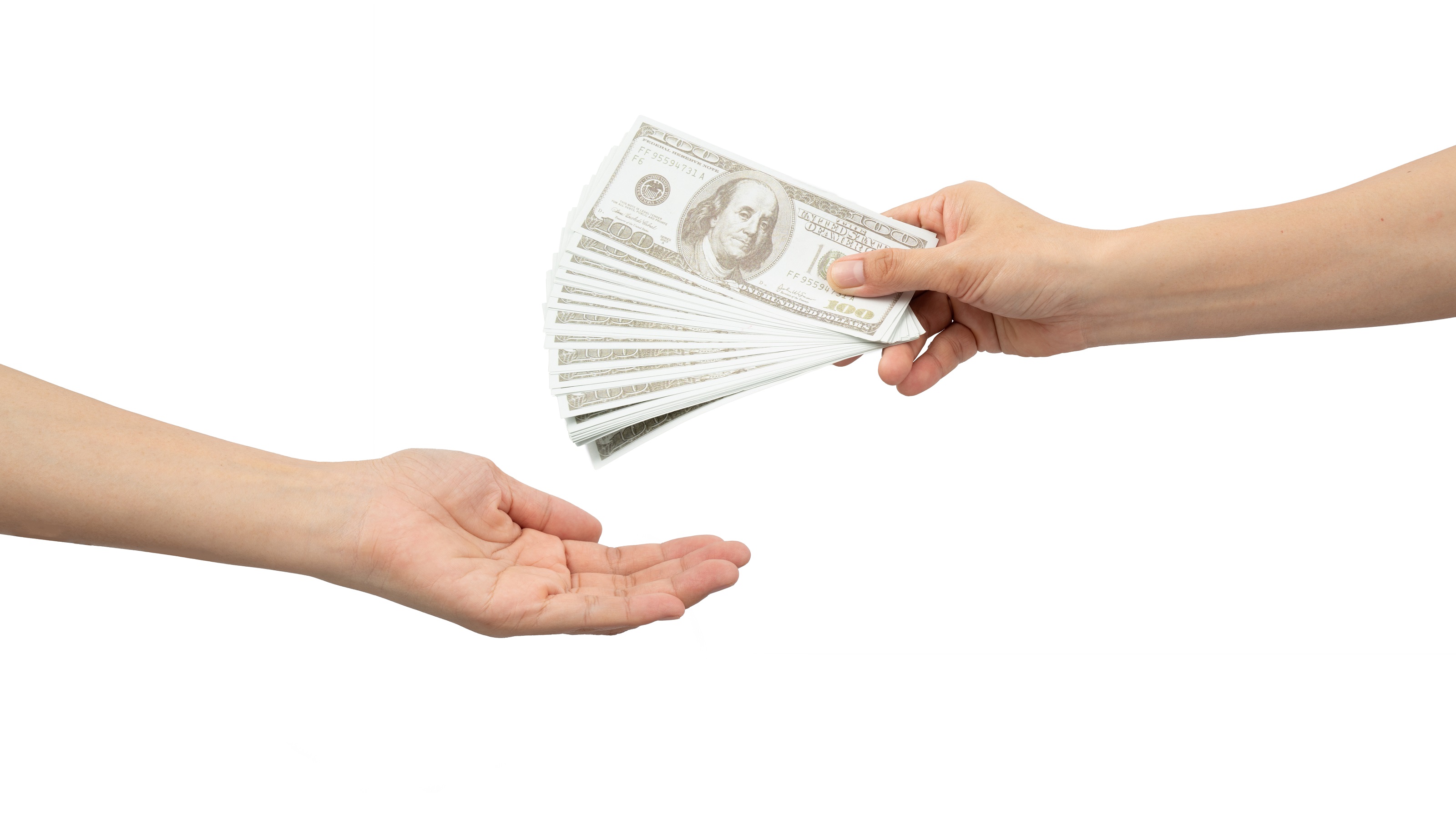 Une main tend des billets de cent dollars déployés en éventail à une autre main.
