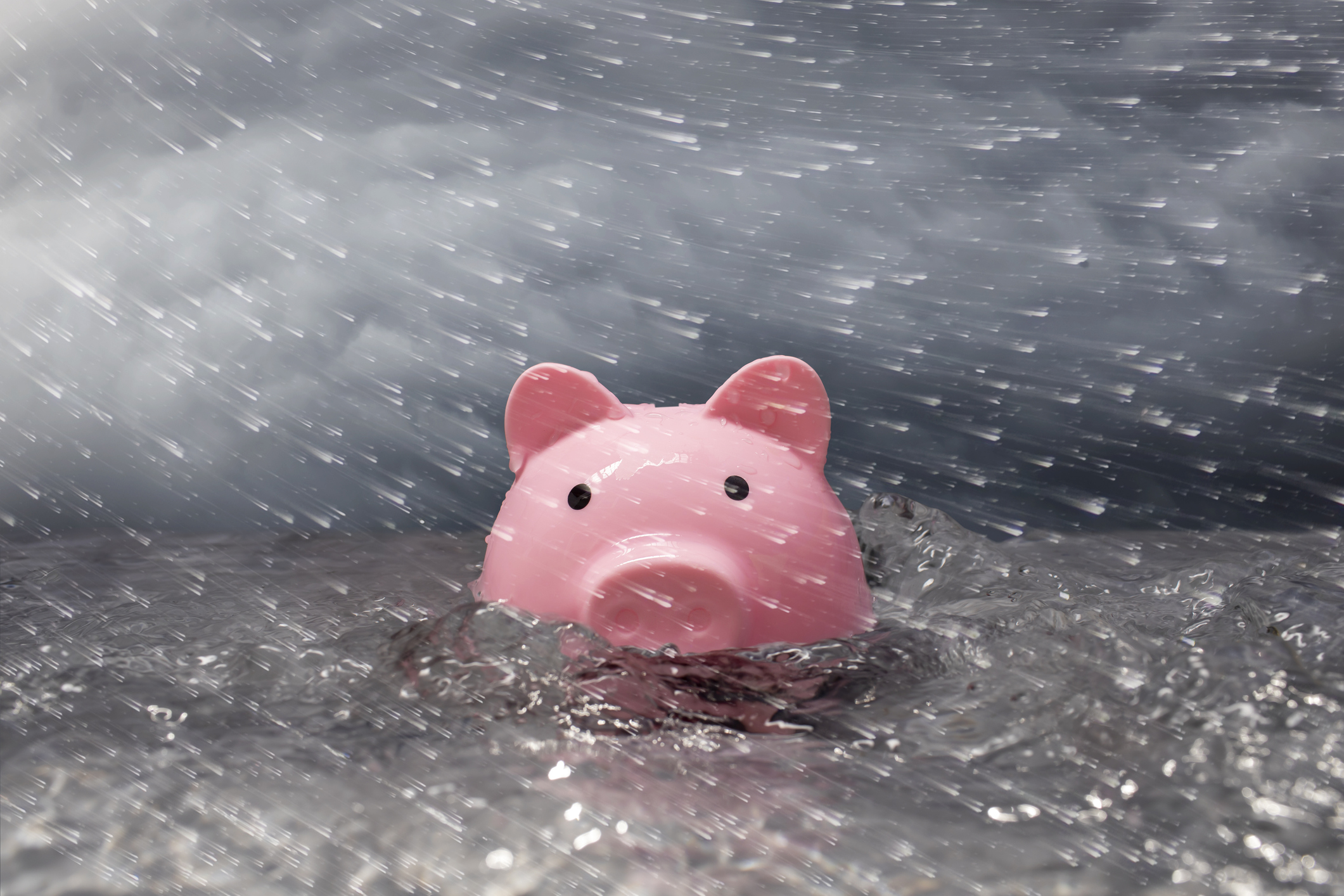 Tirelire rose partiellement immergée dans une eau turbulente, un ciel orageux, une pluie soufflée par le vent