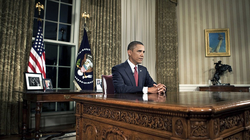 Le président Barack Obama assis derrière son bureau dans le Bureau Ovale en 2010