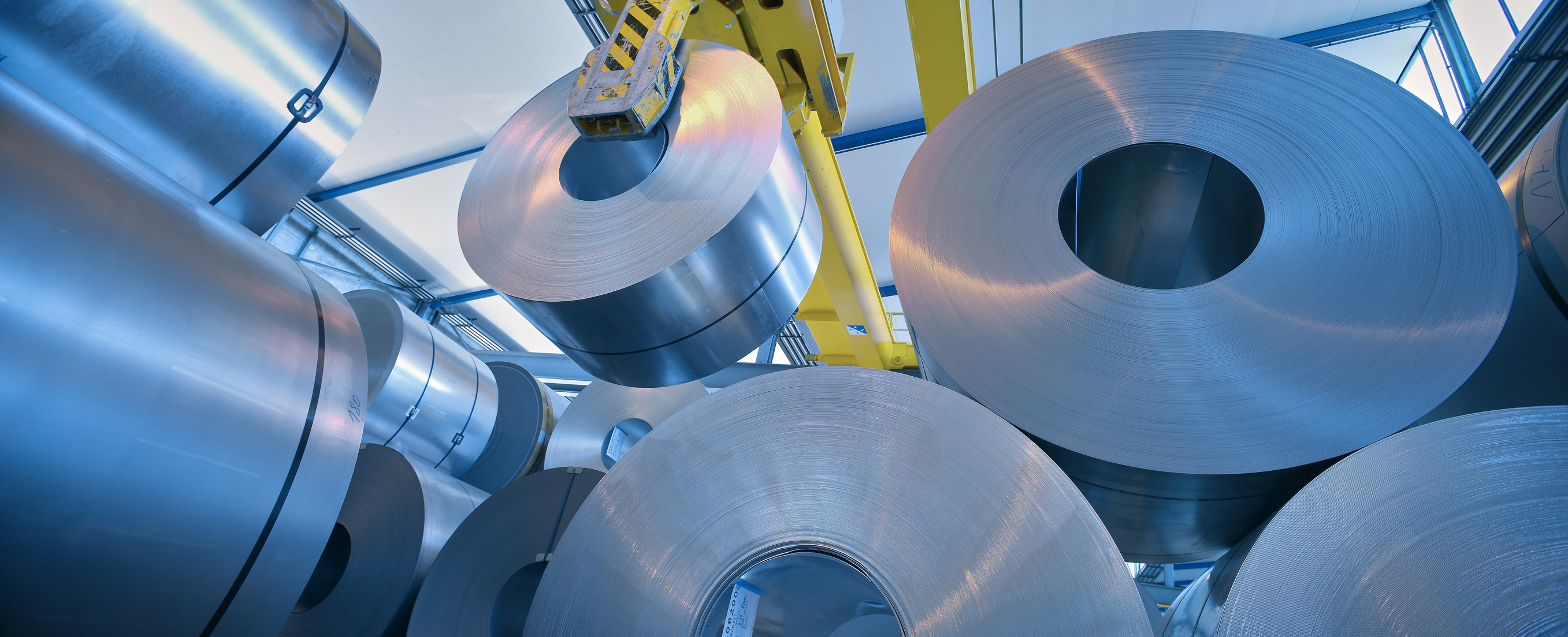 rouleaux d'acier déplacés par une grande machine jaune