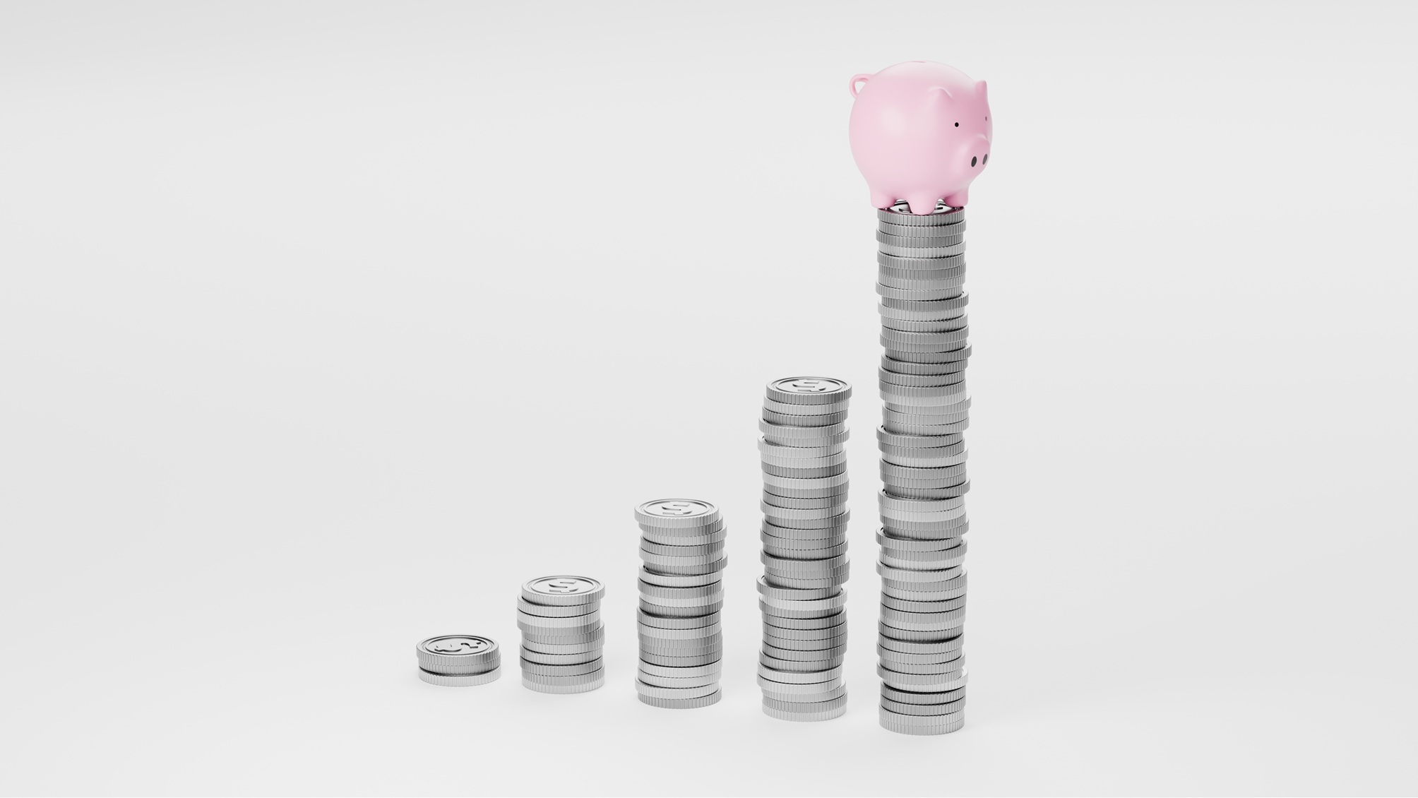 Plusieurs piles de pièces d'argent, une tirelire rose au sommet de la plus haute.